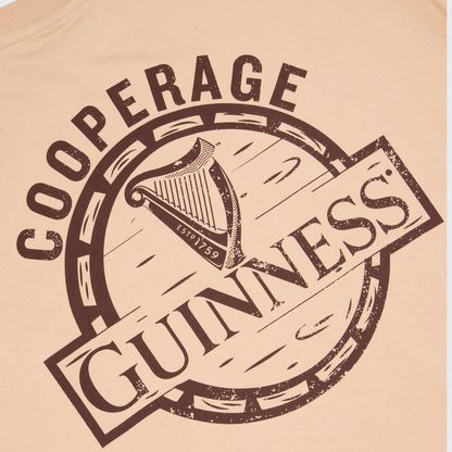 The Guinness Cooperage Ivory Heavyweight Tee features a harp logo and “Cooperage” text in dark brown on an ivory oversized fit. Available at Guinness Webstore US.