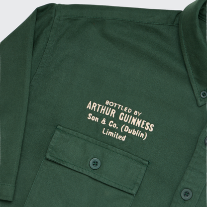 The Guinness Cooperage Work Shirt is a green heavyweight cotton shirt with a chest pocket and cream embroidery: “Bottled by Arthur Guinness Son & Co. (Dublin) Limited.”.