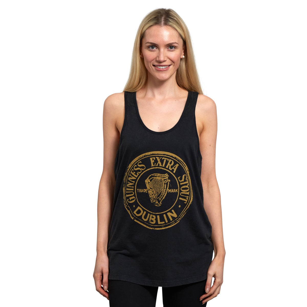 A woman wearing a Guinness Washed Extra Stout Tank Top with a gold logo.