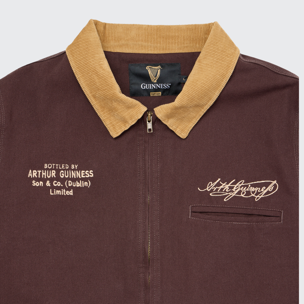 The Guinness Cooperage Work Jacket by Guinness Webstore US features heavyweight brown canvas, tan collar, Arthur Guinness signature, and chest text: “Bottled by Arthur Guinness Son & Co. (Dublin) Limited.”.