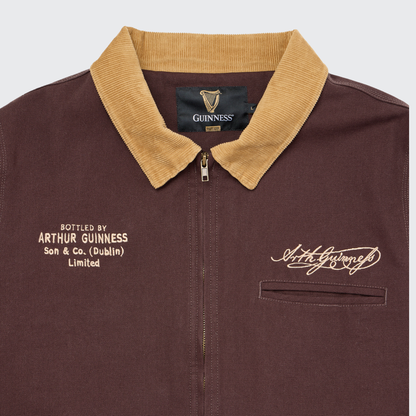 The Guinness Cooperage Work Jacket by Guinness Webstore US features heavyweight brown canvas, tan collar, Arthur Guinness signature, and chest text: “Bottled by Arthur Guinness Son & Co. (Dublin) Limited.”.