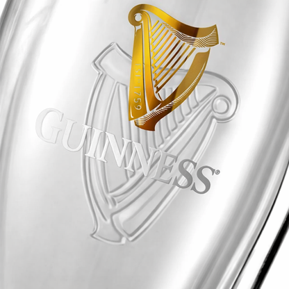 Close-up of the Guinness logo with a gold harp and white text on a reflective silver surface, as seen on official Guinness Gravity Pint Glasses from the Guinness Gravity Pint Glass 2 Pack Gift Set.