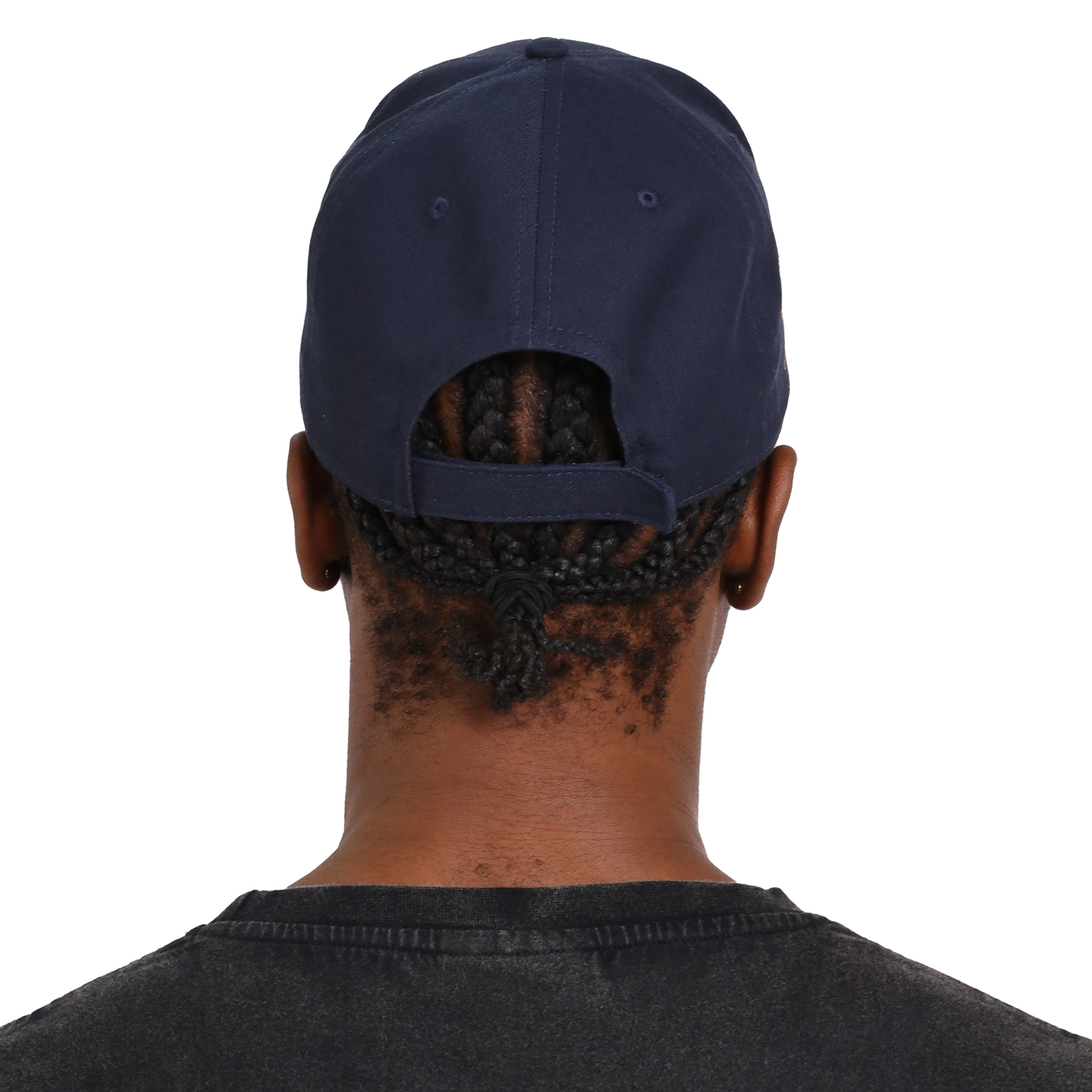 A person with braided hair is seen from the back, donning a Guinness Baseball Cap from the Transport Collection and a black shirt, exuding a timeless style.