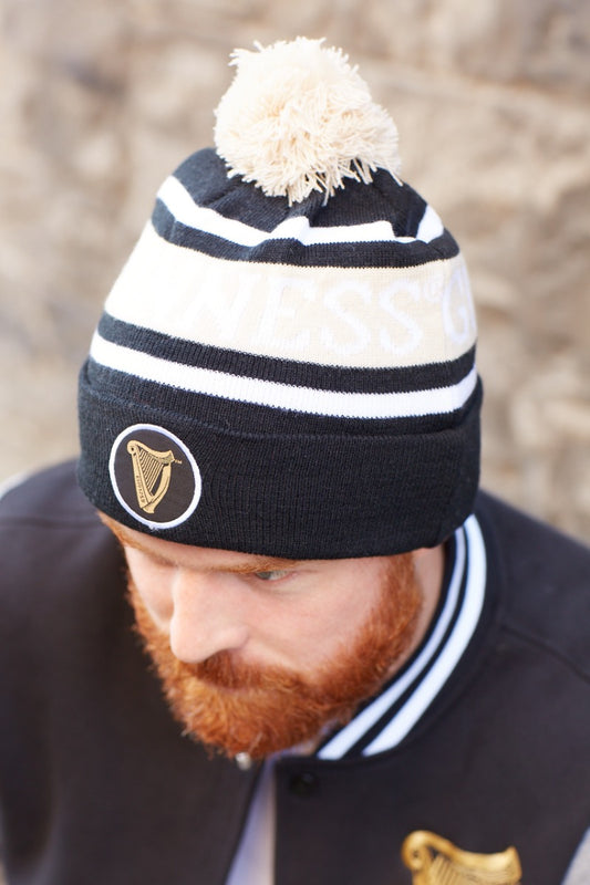A man with a warm and cozy beard wearing a Guinness Black and White Premium Beanie.