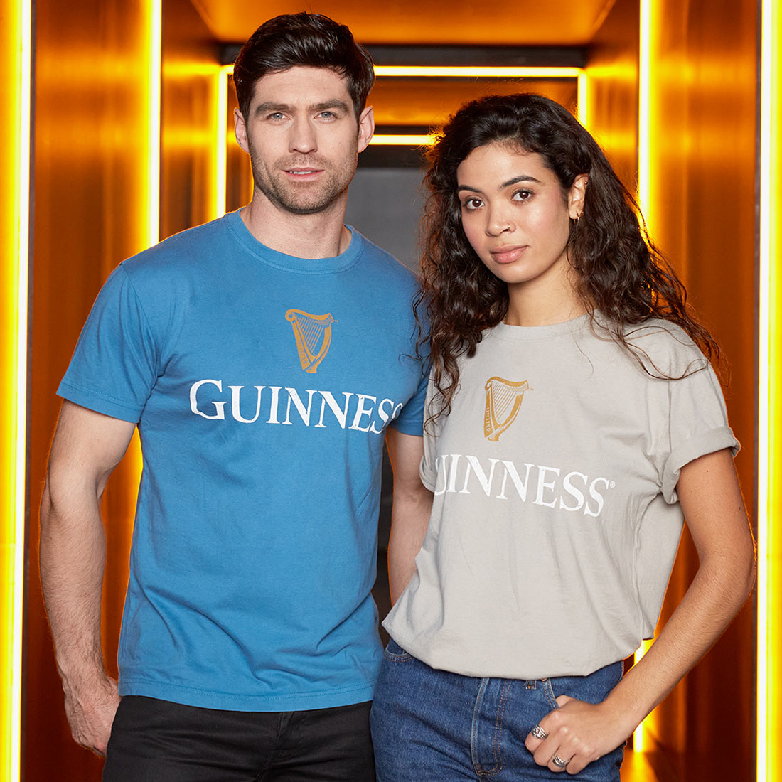 A man and woman proudly don matching Guinness Trademark Label T-Shirt Beige made of cotton.