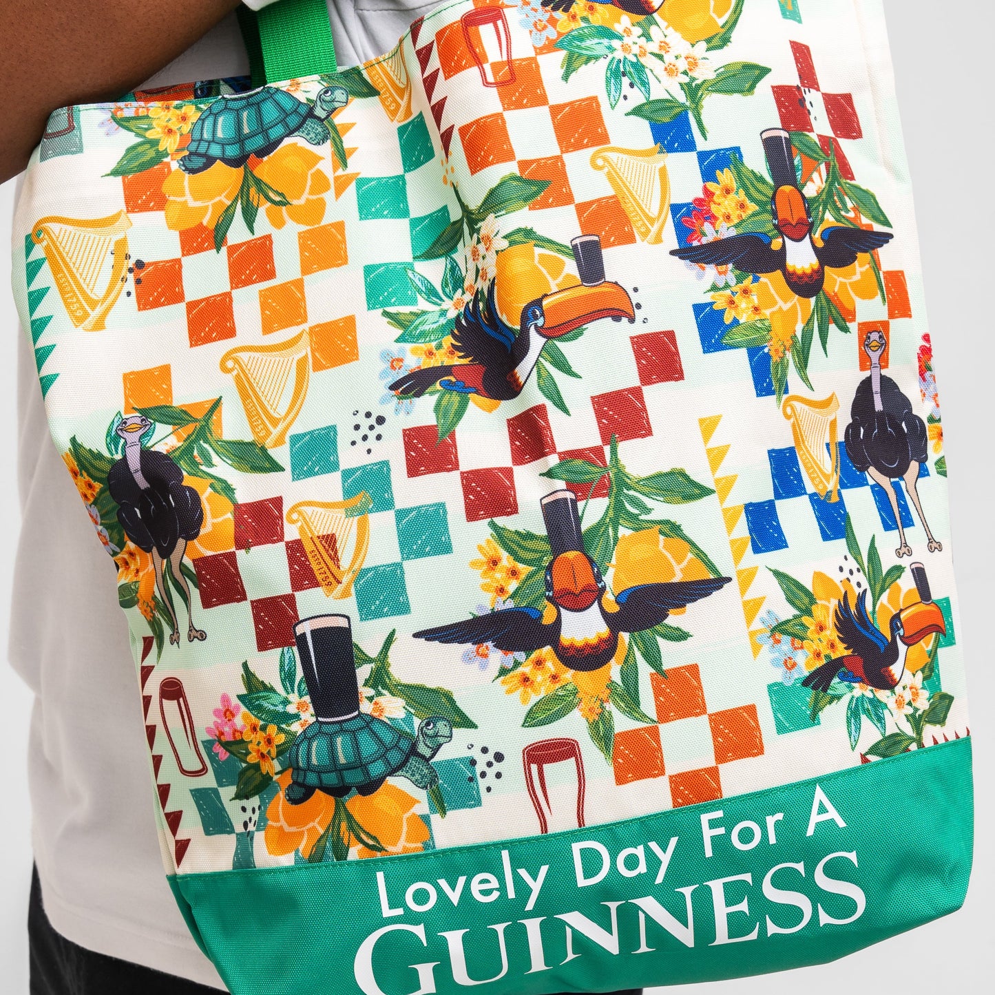The Guinness Toucan Beach Bag from Guinness Webstore US showcases toucan prints, beer glass and shamrock motifs, plus “Lovely Day For A Guinness” text on durable polyester—ideal as a vibrant beach accessory.