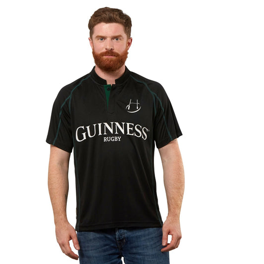 A man wearing a Guinness Black & Green Short Sleeve Rugby Jersey.