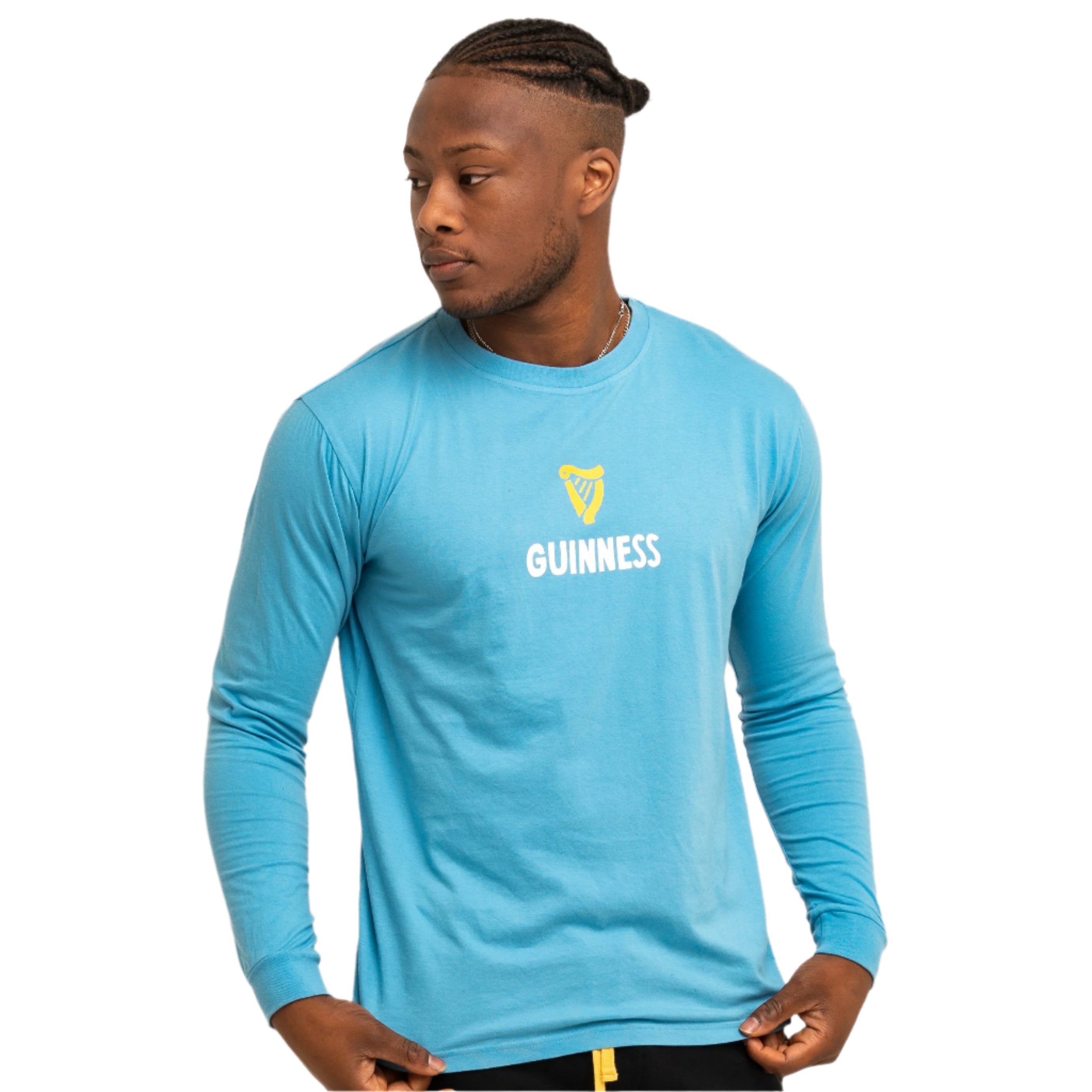 A man models the Guinness Seb Curi Lovely Day Longsleeve Tee in blue, featuring the yellow Guinness logo and text, inspired by Sebastian Curi, against a plain white background. Available at Guinness Webstore US.