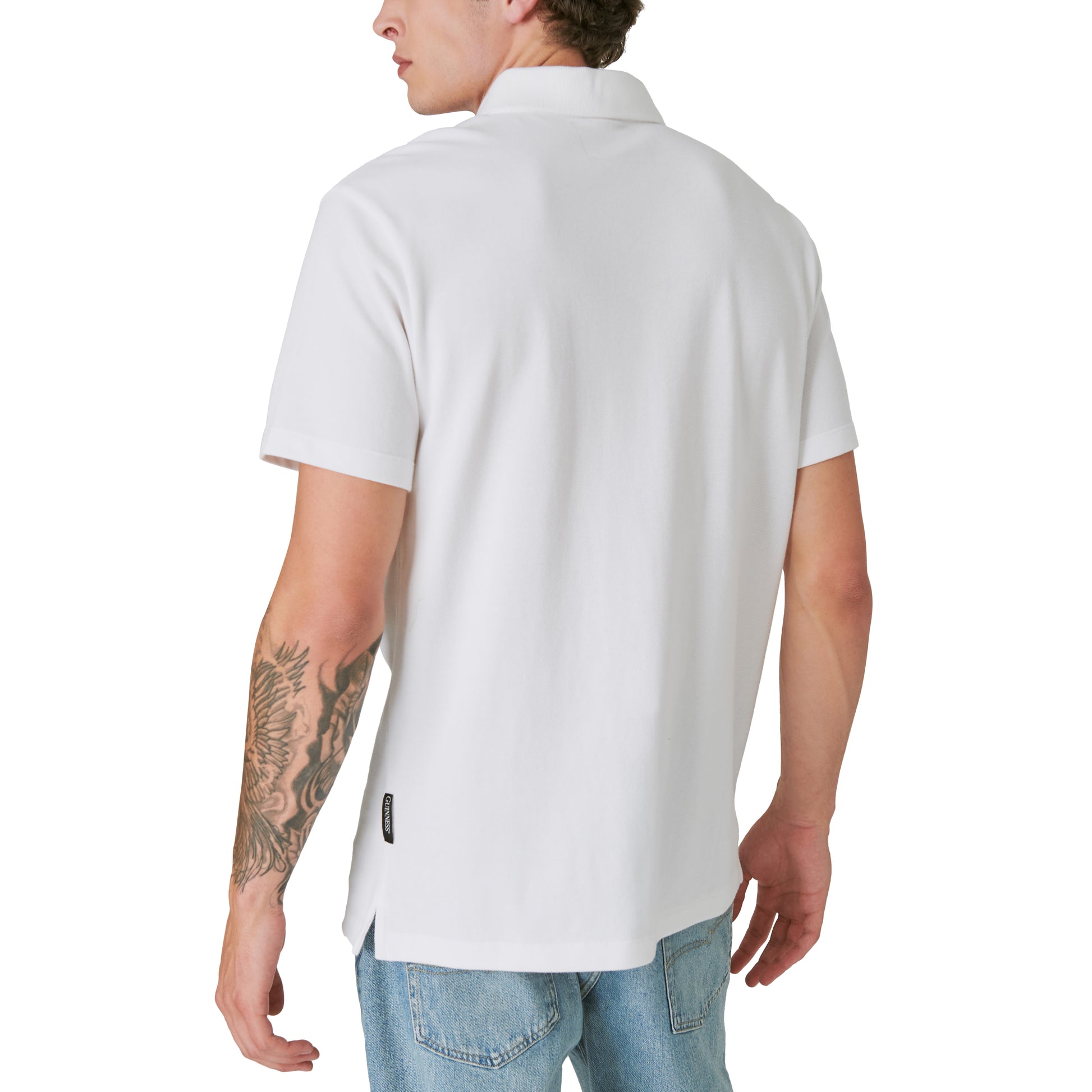 The limited edition Guinness Polo - Bright White showcases the back view of a man wearing a white polo shirt.