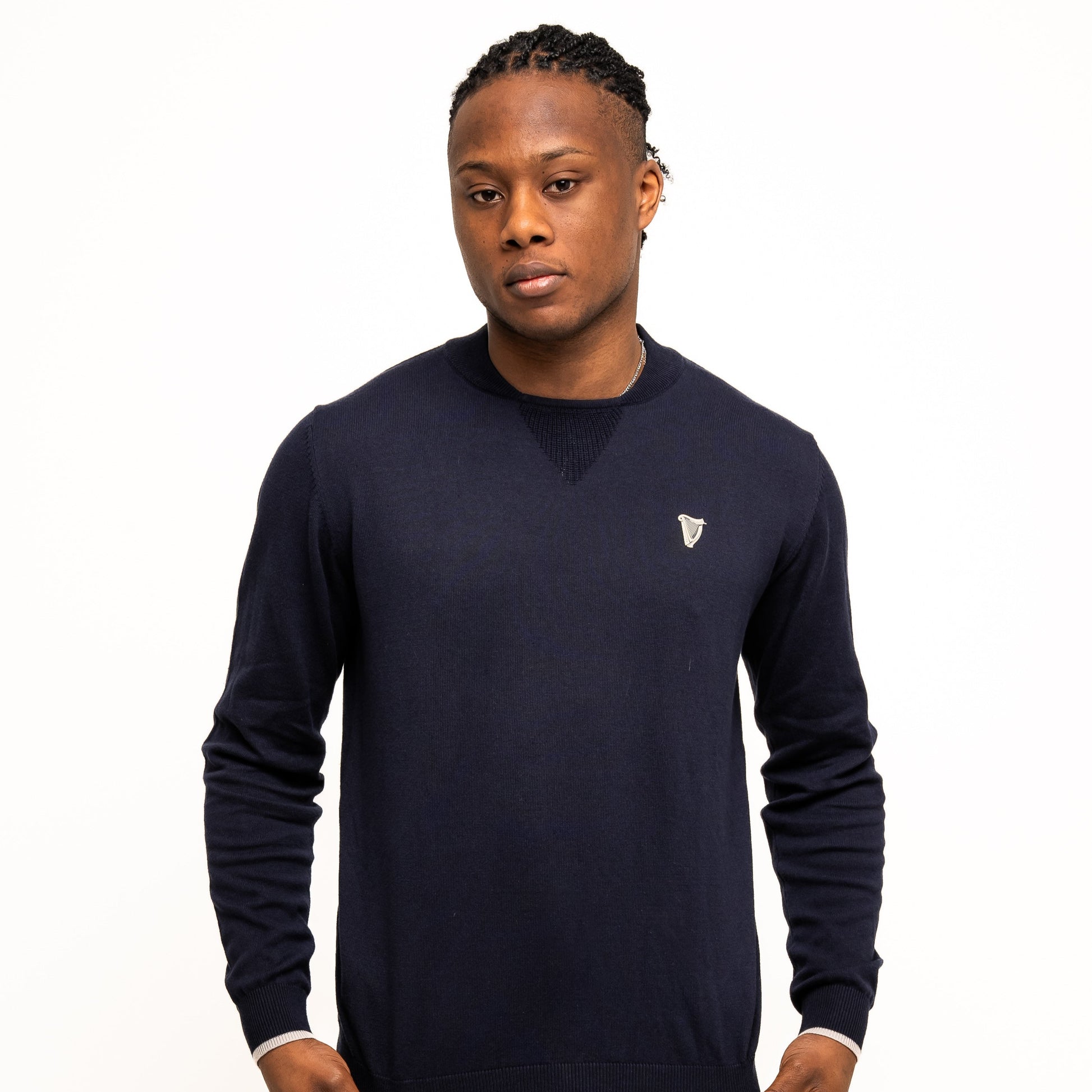 A person wearing the Guinness Webstore US Guinness Performance Cotton Sweater - Navy and navy blue shorts stands against a plain white background.
