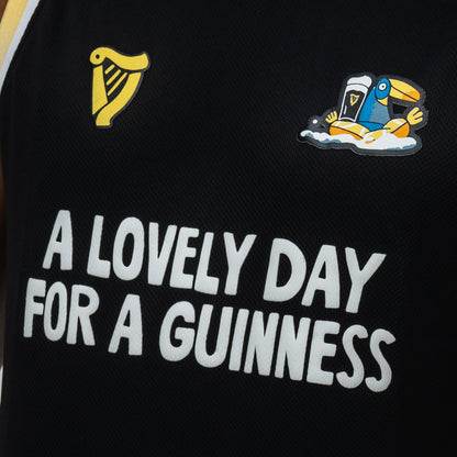 The Guinness Seb Curi Basketball Jersey from Guinness Webstore US features a black design with “A LOVELY DAY FOR A GUINNESS,” harp logo, and cartoon toucan—part of the exclusive Sebastian Curi collaboration.