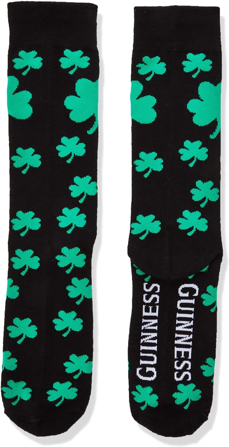 The Guinness Shamrock Socks by Guinness showcase a black fabric embellished with green shamrocks, with "GUINNESS" proudly displayed on the soles, making them ideal for any fan of Guinness.