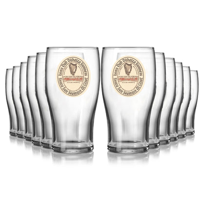 Enjoy your Extra Stout with the Guinness Vintage Label Pint Glass - 12 Pack from Guinness Webstore US—each glass features a harp logo and circular text design for an authentic experience.