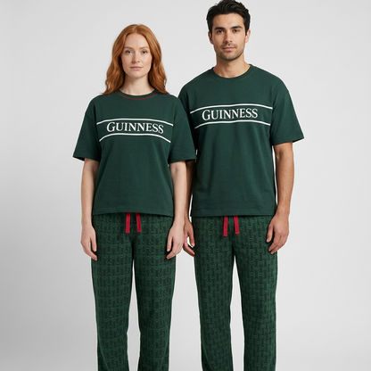 Two people wear the Guinness Unisex 2-Piece Pajama Set – Green from Guinness Webstore US, a fun gift featuring matching tops and patterned pants.