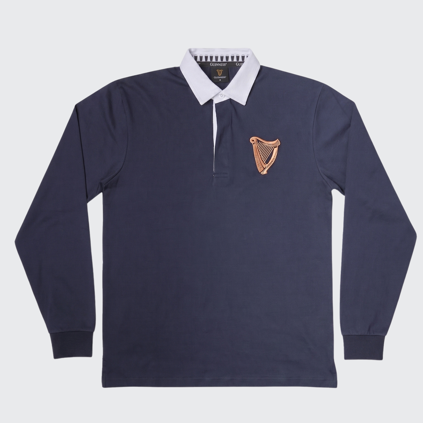 Guinness Webstore US Guinness Navy Traditional Rugby Jersey featuring a classic white collar and a gold harp emblem on the left chest, shown against a plain background.