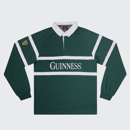 Guinness Green Traditional Rugby Jersey by Guinness features long sleeves, classic white stripes and collar, and a “Guinness” logo across the chest. A gold harp emblem on the sleeve adds an authentic Irish rugby touch.