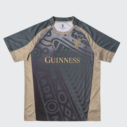 The Guinness Retro Harp Performance Soccer Jersey by Guinness is a short-sleeve athletic shirt featuring black, gray, and beige panels with “Guinness” and harp logos on the front, complemented by abstract graphic design elements—a classic-inspired retro jersey that blends style and performance.