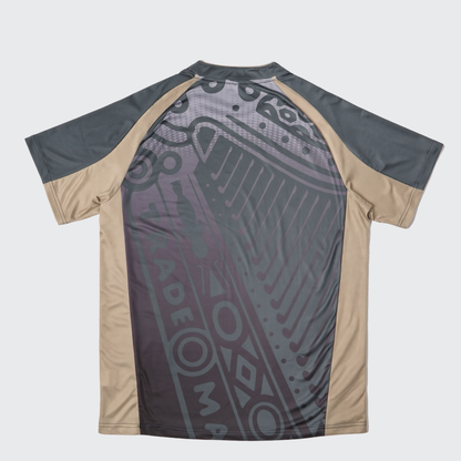 Introducing the Guinness Retro Harp Performance Soccer Jersey by Guinness—a short-sleeved soccer jersey featuring dark gray and beige paneling, complete with a geometric and tribal-inspired pattern on the back.