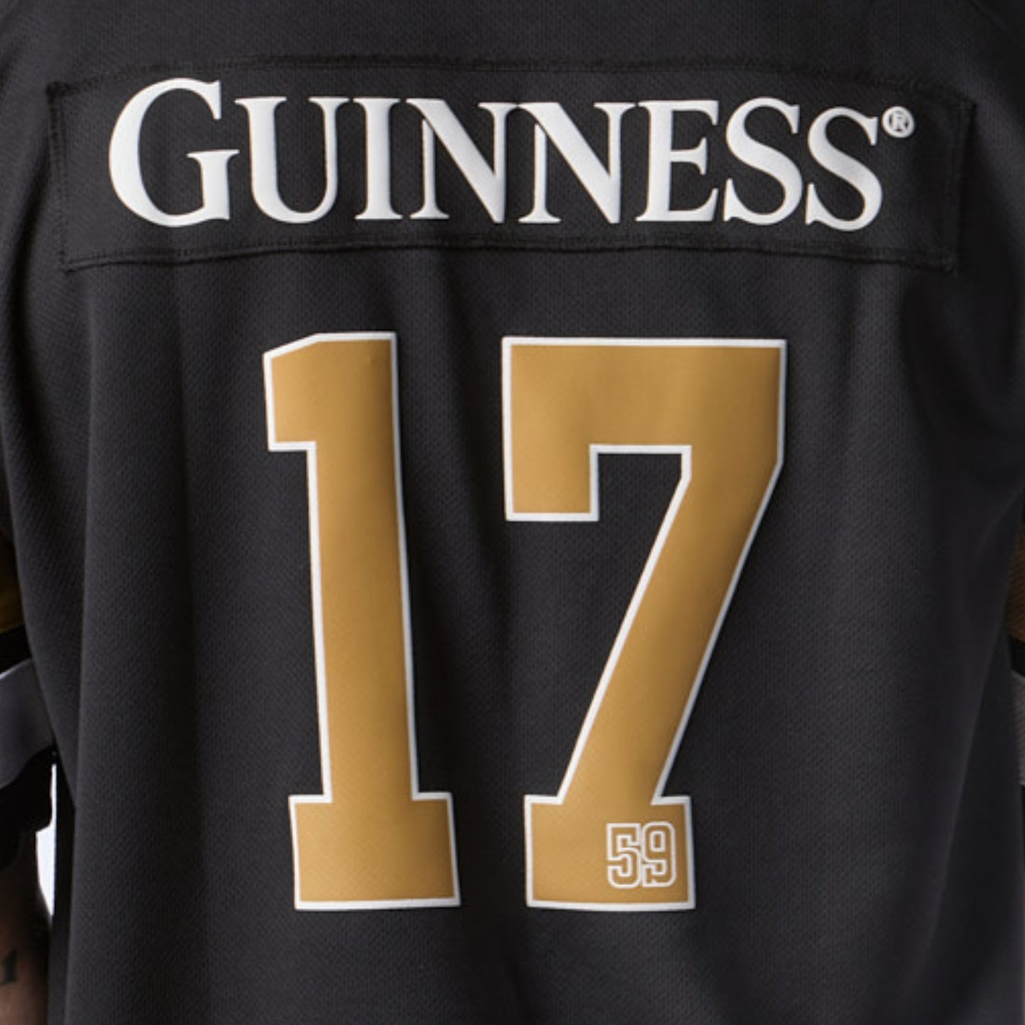 The Guinness Black American Football Jersey from Guinness Webstore US is a stylish black jersey featuring “GUINNESS” on the back and the number 17 in gold and white—perfect for fans wanting standout Guinness apparel.