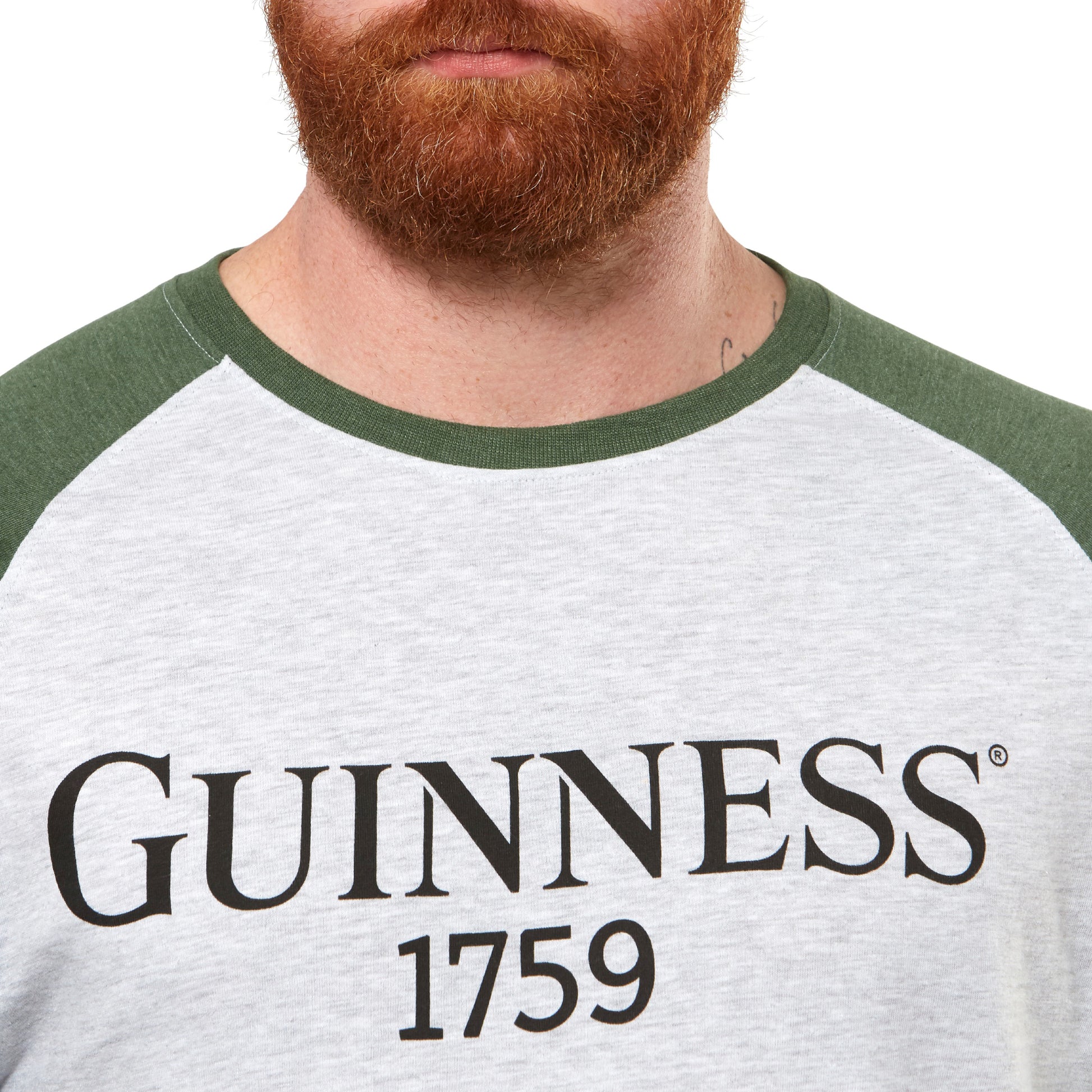 A man with a beard is wearing a Guinness baseball t-shirt.