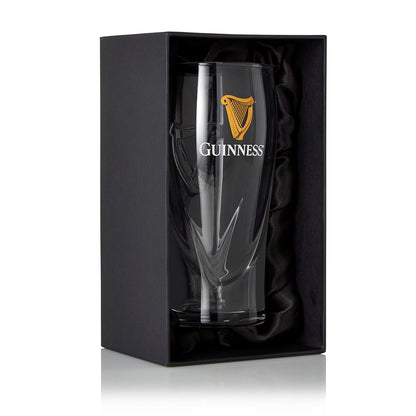 The Guinness Pint Glass Luxury Gift Box from Guinness Webstore US features a clear pint glass with a gold logo, presented upright in a black gift box lined with black fabric—the ideal gift for any Guinness fan.