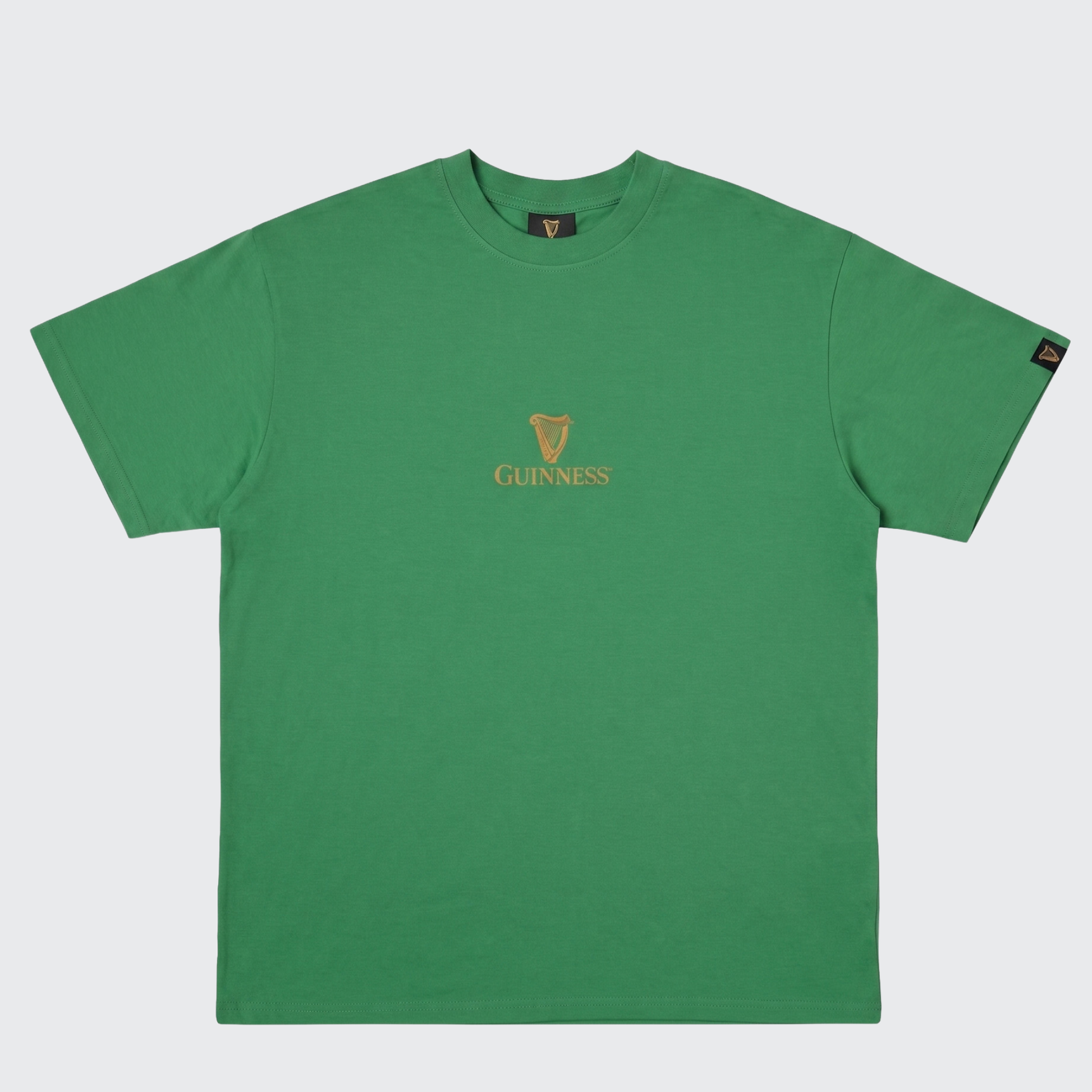 The Guinness Gilroy Toucan Tee – Green from Guinness Webstore US is a short-sleeve boxy tee featuring the iconic Guinness logo and gold harp emblem centered on the chest, inspired by the classic Gilroy collection.