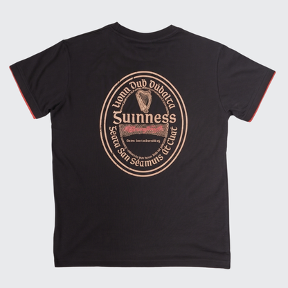 The Guinness Irish Label Black Tee from the Guinness Webstore US showcases a bold vintage-inspired Guinness label and harp graphic on the back, complete with English and Irish text and eye-catching red sleeve trim. It’s the ideal black tee for fans looking to celebrate classic Irish beer style.