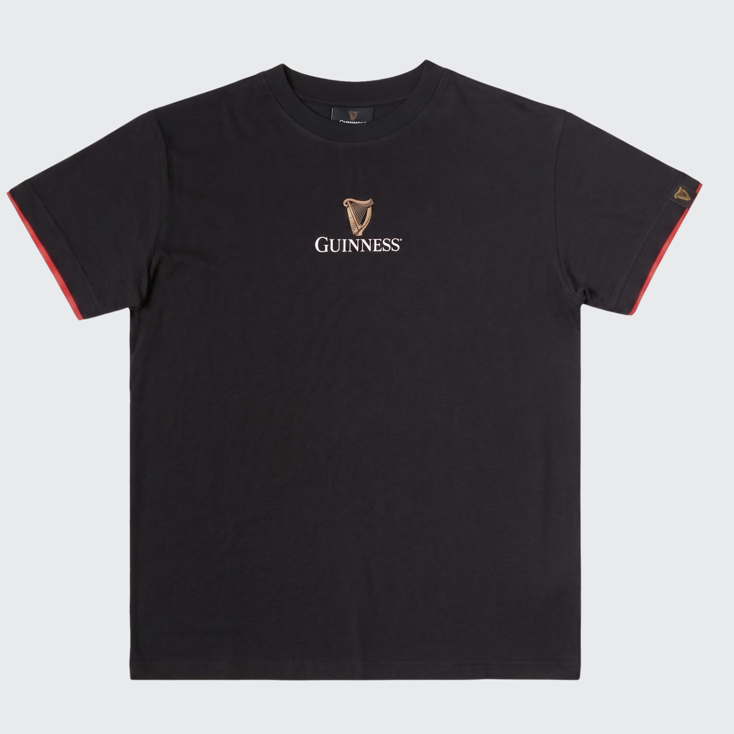 The Guinness Irish Label Black Tee from Guinness Webstore US features a black short-sleeve design with the iconic Guinness logo and harp emblem printed in white and gold on the chest, making it a perfect choice for fans of this legendary Irish beer.