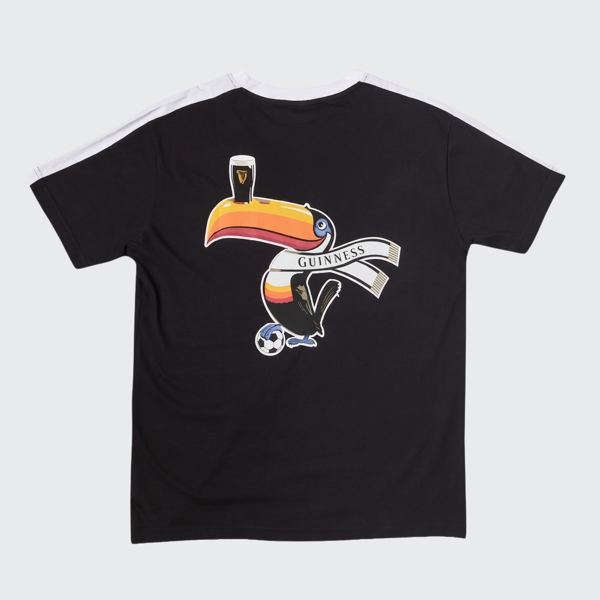 The Guinness Toucan Soccer Black Tee from Guinness Webstore US showcases a vibrant graphic of a toucan balancing a pint of “Guinness” on its beak while holding a banner and standing over a soccer ball. Bold white shoulder stripes add an athletic touch to this sporty graphic tee.