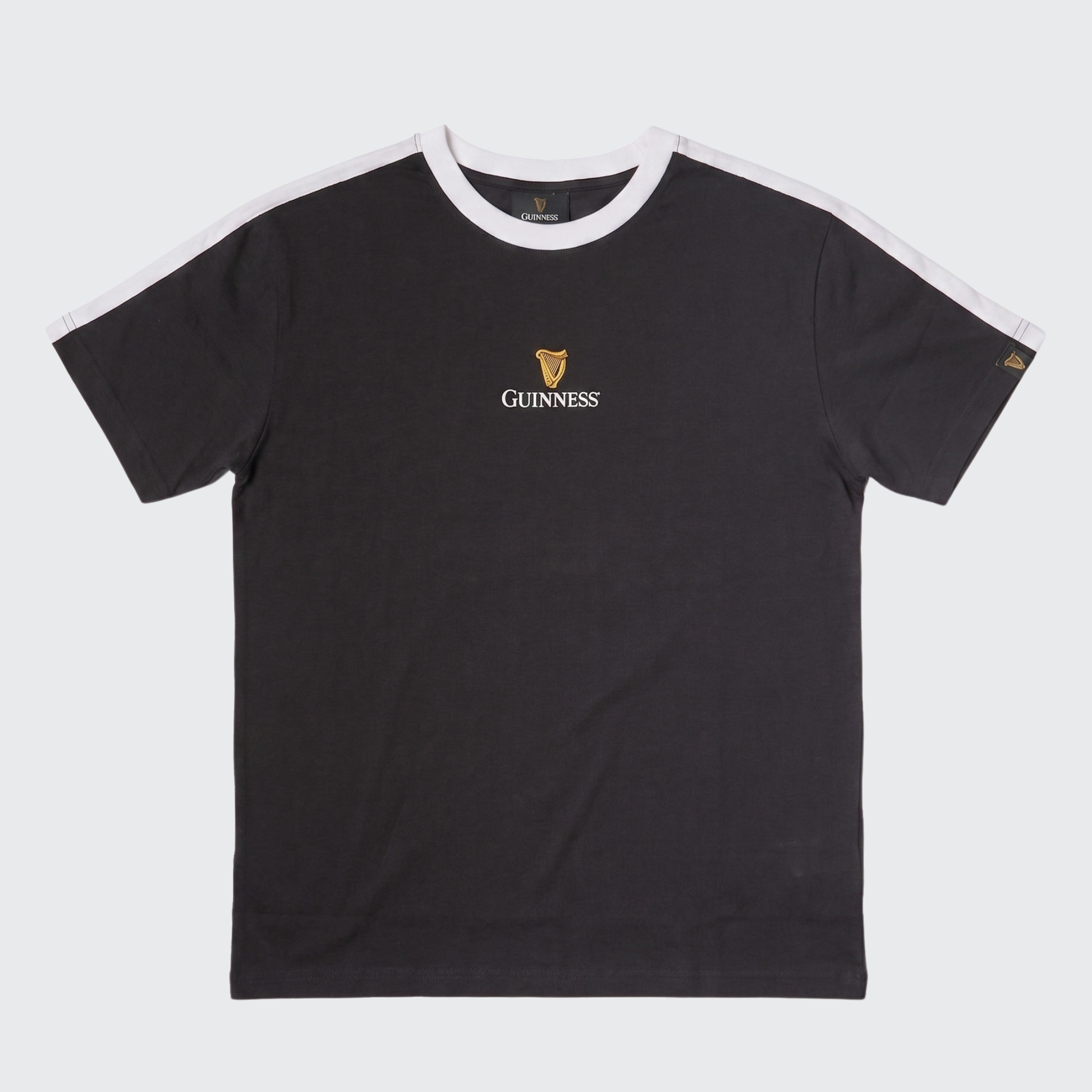 The Guinness Toucan Soccer Black Tee from Guinness Webstore US features black short sleeves, white shoulder stripes, and a small gold Guinness logo with harp emblem on the chest—offering fans a classic, iconic soccer-inspired look.