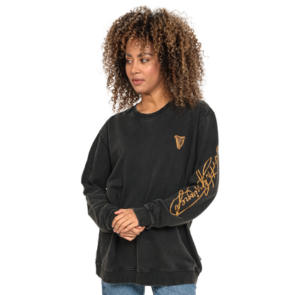 Guinness Gold Harp & Signature Distressed Sweatshirt in black, featuring a gold harp logo on the chest and gold cursive text along the left sleeve.