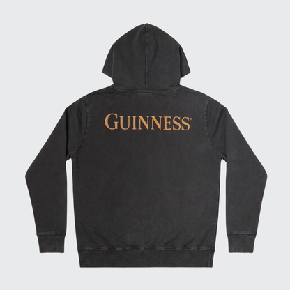 Black hooded sweatshirt with “GUINNESS” printed in large gold letters across the back, laid flat on a white background. The Guinness Evolution of the Harp Distressed Hoodie – Black from Guinness Webstore US features a comfortable distressed cotton design, perfect for any fan of the iconic brand.