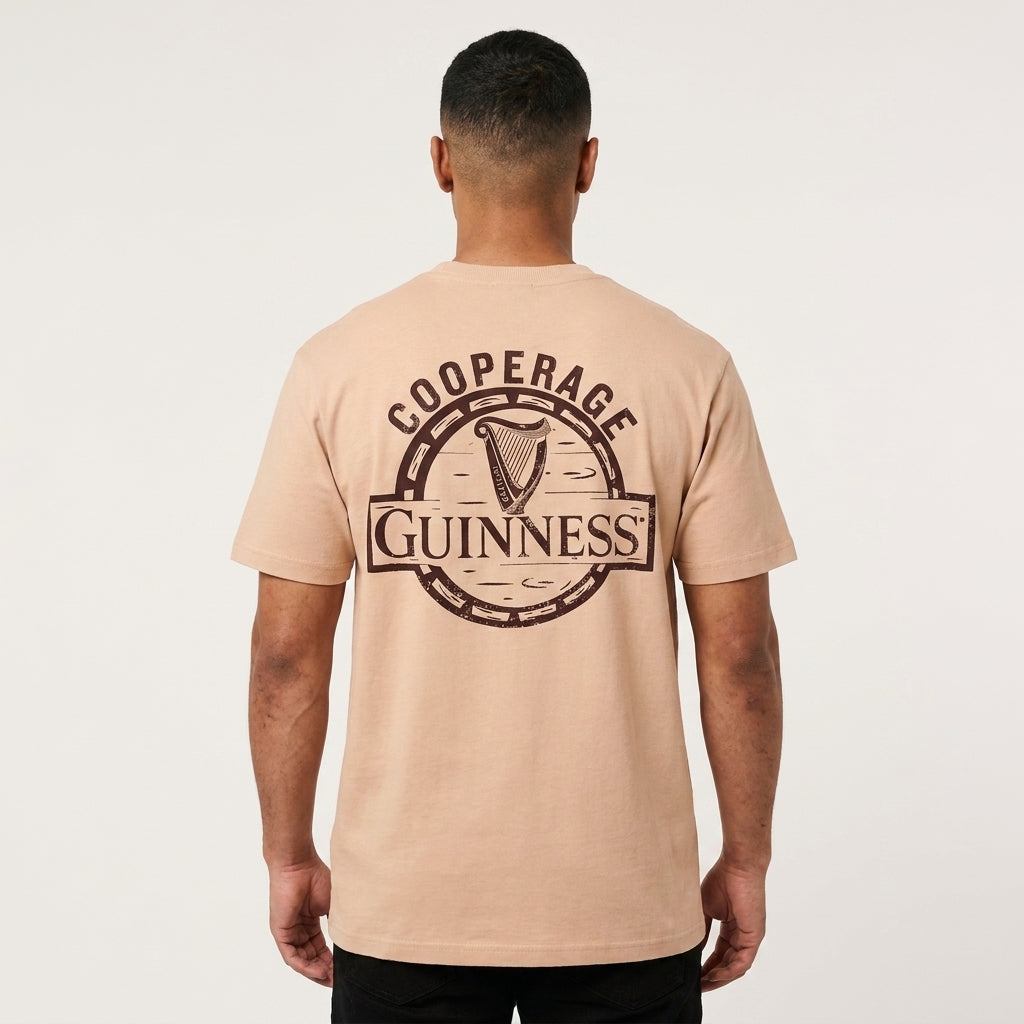 Man facing away in an oversized fit Guinness Cooperage Ivory Heavyweight Tee, large logo and “Cooperage” on the back. Brand: Guinness Webstore US.