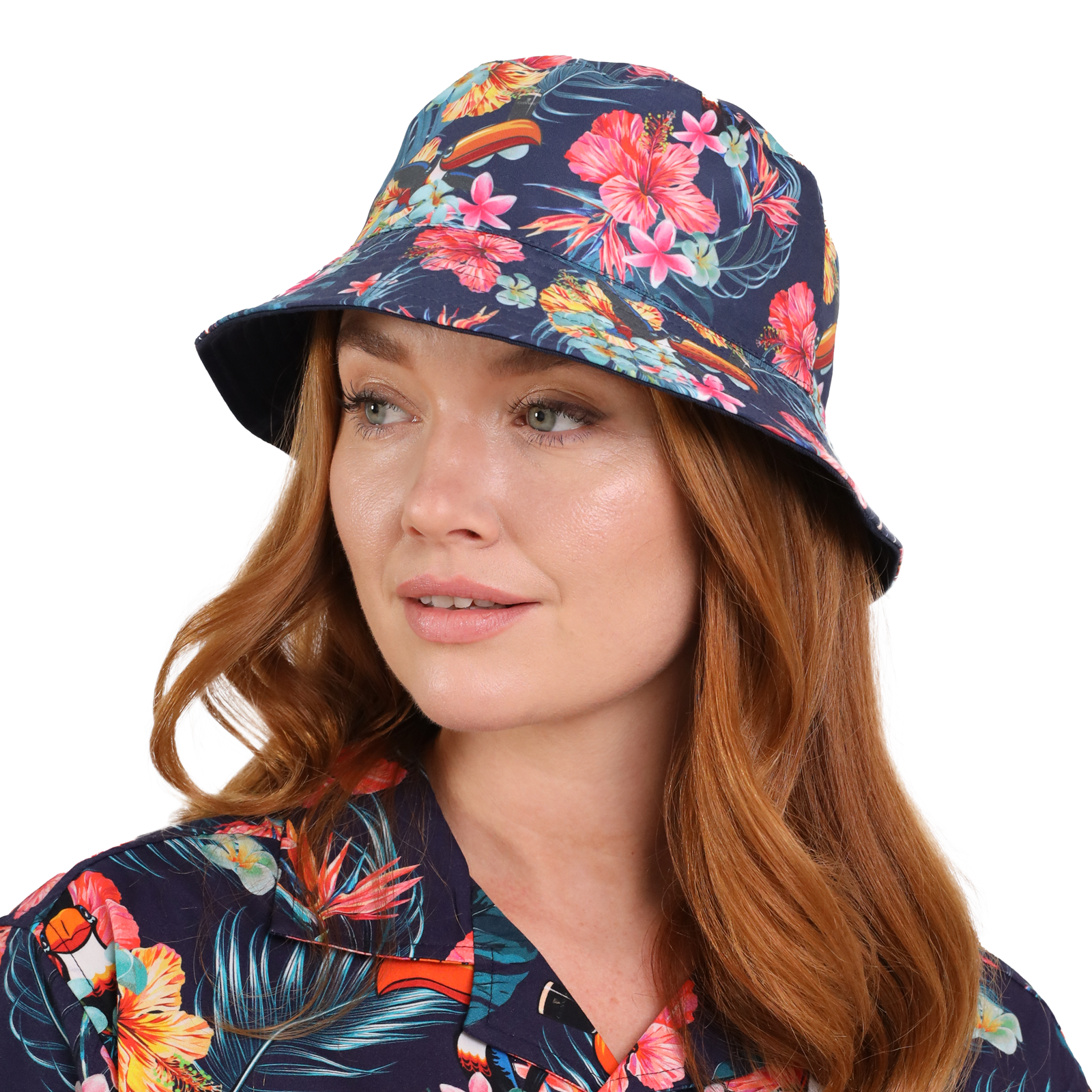 A woman with red hair is wearing a vibrant floral Guinness Hawaiian Reversible Bucket Hat and matching shirt from the Guinness Webstore US, looking to the side.