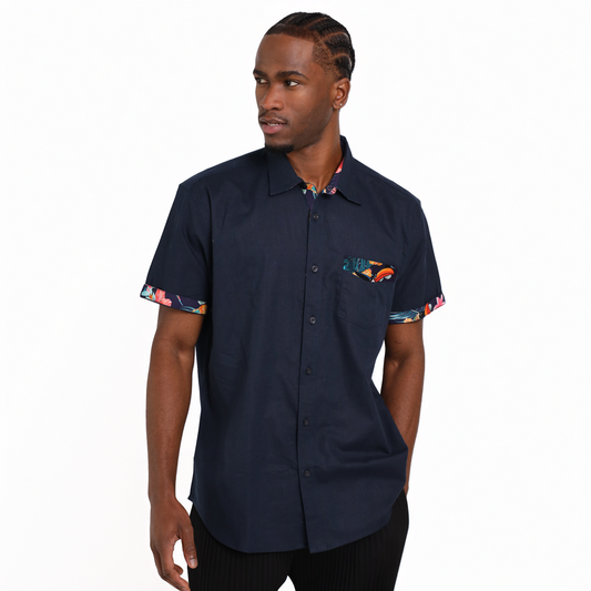 A man stands against a plain white background wearing the Guinness Navy Linen Summer Shirt by Guinness Webstore US, a short-sleeve button-up featuring patterned trim on the cuffs, pocket, and collar.