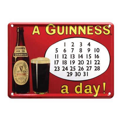 The Guinness Metal Calendar Sign – A Guinness a Day from Guinness Webstore US features a vintage-style bottle and glass beside a calendar with "A GUINNESS a day!" text on red—ideal nostalgia décor for any space.