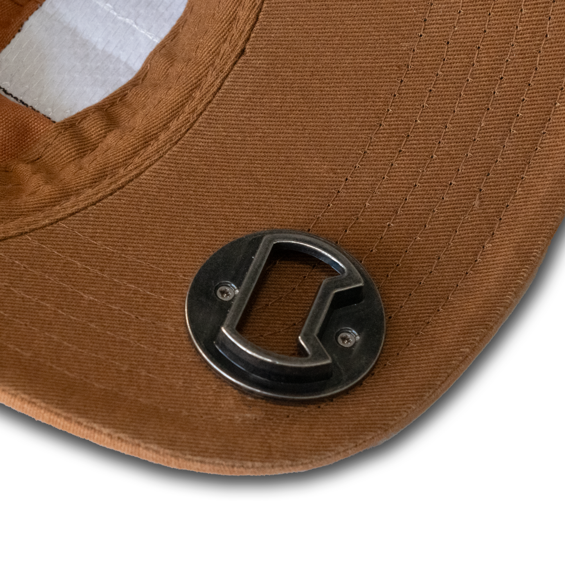 A close-up of the Guinness Mustard Bottle Opener Cap showcases the brown brim with a metallic bottle opener, highlighting the visible stitching and fabric texture that accentuates the craftsmanship alongside the iconic Guinness® Harp Logo.