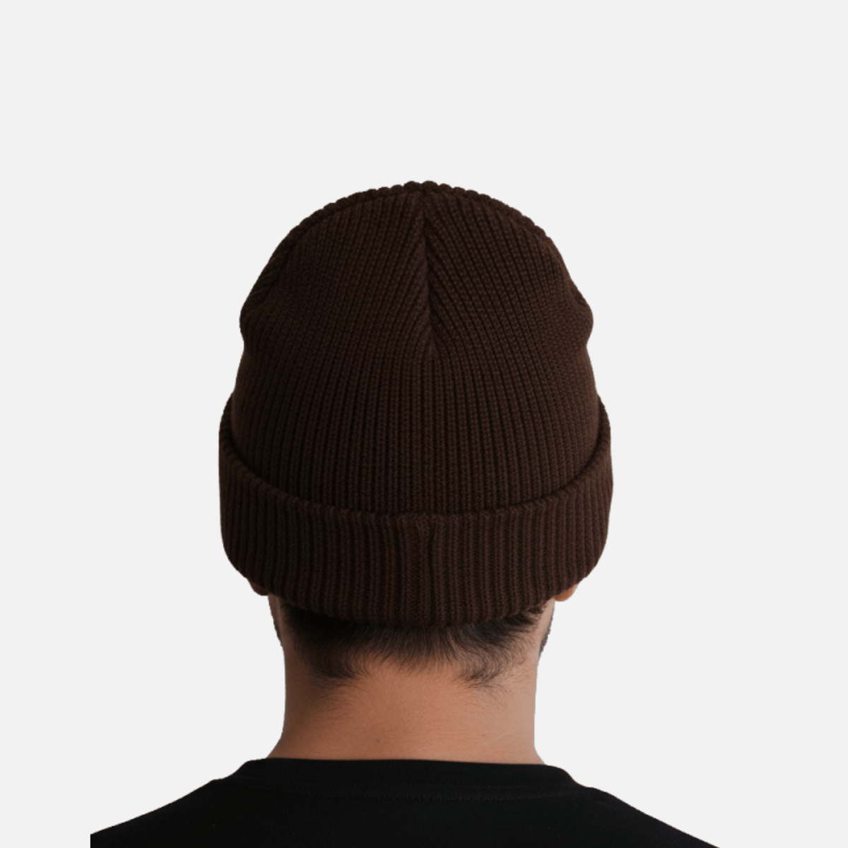 Person wearing a Guinness Cooperage Brown Knitted Beanie, viewed from behind against a plain white background. Brand: Guinness Webstore US.