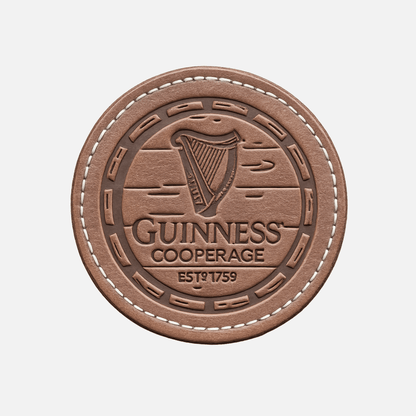 Embossed leather coaster with harp, “Guinness Cooperage,” and “Est. 1759”—pairs perfectly with the Guinness Cooperage Brown Knitted Beanie from Guinness Webstore US.