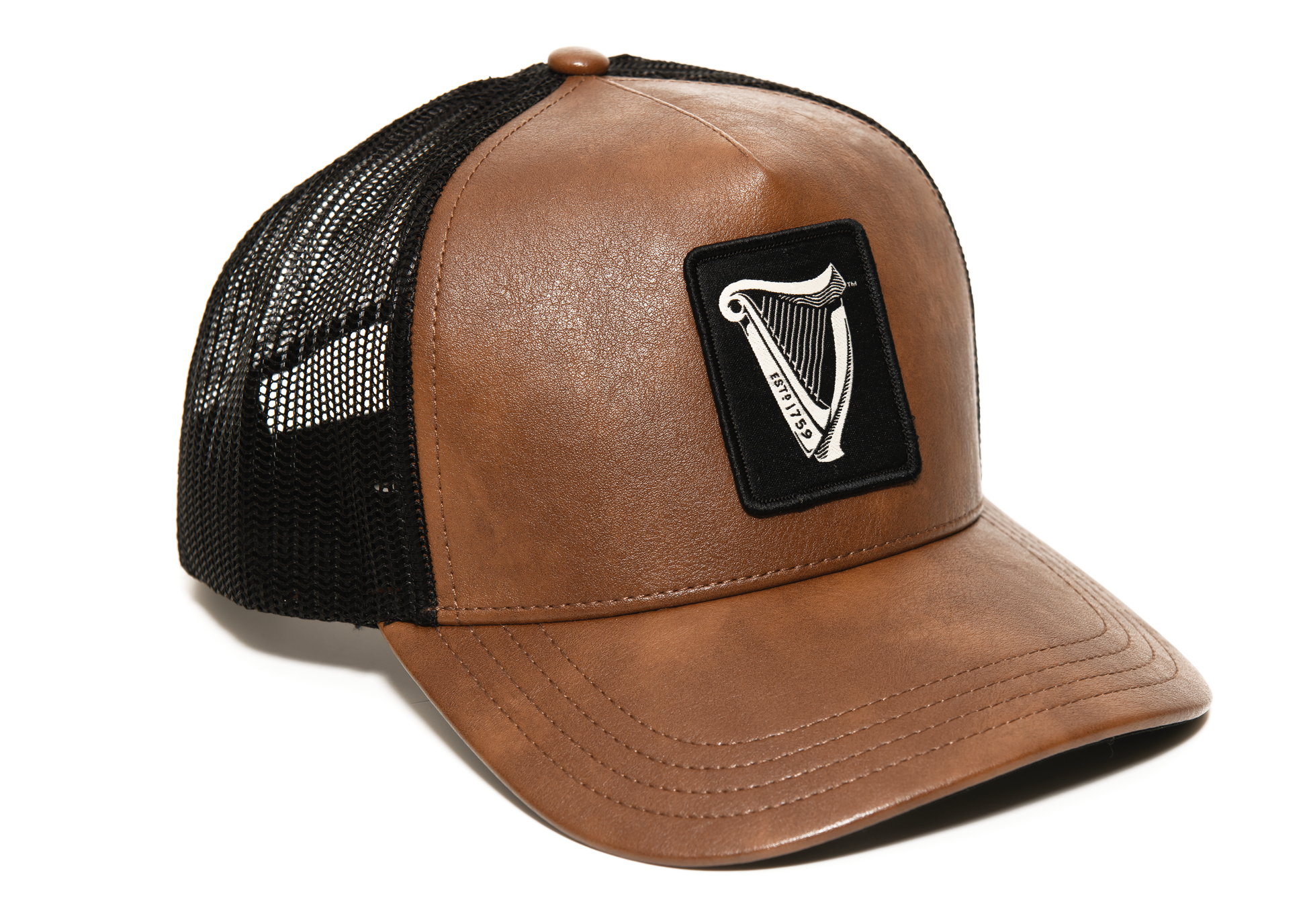 The Guinness Brown Leather Trucker Cap from the Guinness Webstore US features a brown and black mesh design, adorned with a Guinness Harp Logo patch on the front panel and accented by a chic leather peak.