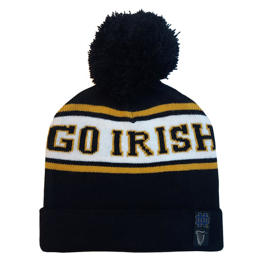 Navy blue hat with a black pom-pom, perfect for your winter wardrobe. White band with yellow and black letters saying "GO IRISH," showcasing Irish pride. It features a small logo patch near the cuff, making it the ideal Guinness Notre Dame Bobble Hat from Guinness Webstore US.