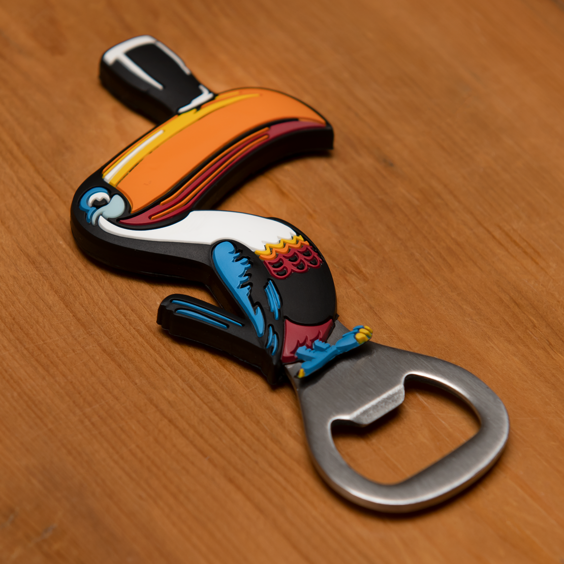 The Guinness Toucan Opener Magnet by Guinness rests gracefully on a wooden surface, seamlessly combining function with charm.