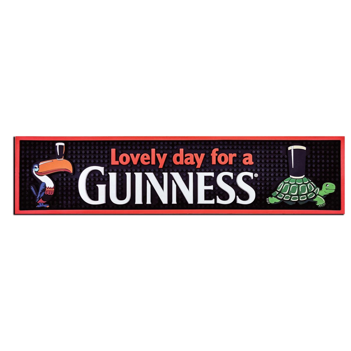 Guinness Gilroy Toucan & Turtle PVC Bar Mat, a rectangular mat featuring a toucan on the left and a turtle on the right balancing stout glasses, with “Lovely day for a GUINNESS” in the center.