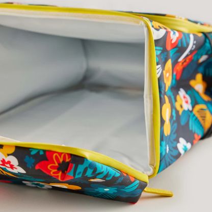 The Guinness x Fatti Burke Hawaiian Cooler Bag from Guinness Webstore UK, with a vibrant floral design and yellow zipper, displays its empty silver insulated interior featuring unique Fatti Burke illustrations.