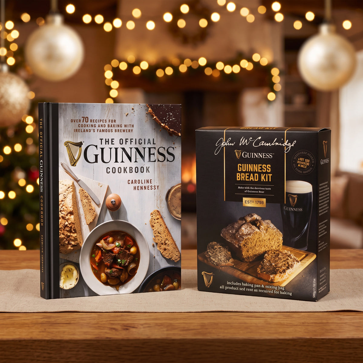 The Guinness Baking Gift Set from Guinness Webstore US, with a cookbook and bread kit, is displayed on a wooden table with holiday lights softly blurred in the background.