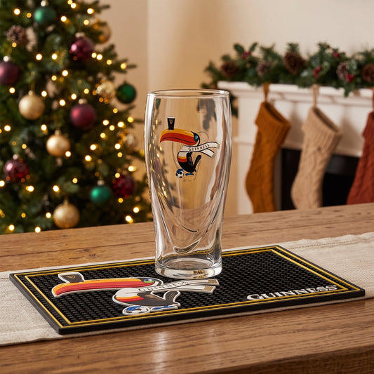 The Guinness Soccer Holiday Gift Set from Guinness Webstore US is the perfect soccer gift, featuring a toucan glass and bar mat amid festive Christmas decor.