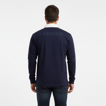 A man faces away in a Guinness Webstore US Navy Long Sleeve Rugby Shirt—100% cotton with "Guinness" across the back—showcasing classic Irish style against a plain white background.