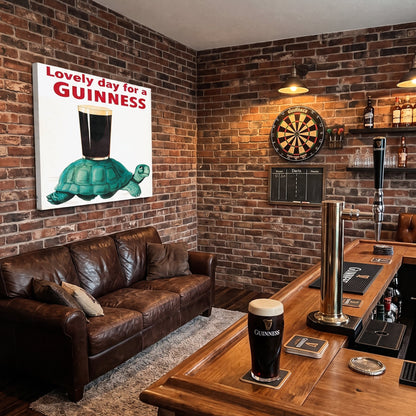 Guinness Gilroy Tortoise Canvas Art on a brick wall, featuring a green tortoise carrying a pint of stout with the text “Lovely day for a GUINNESS” above it.