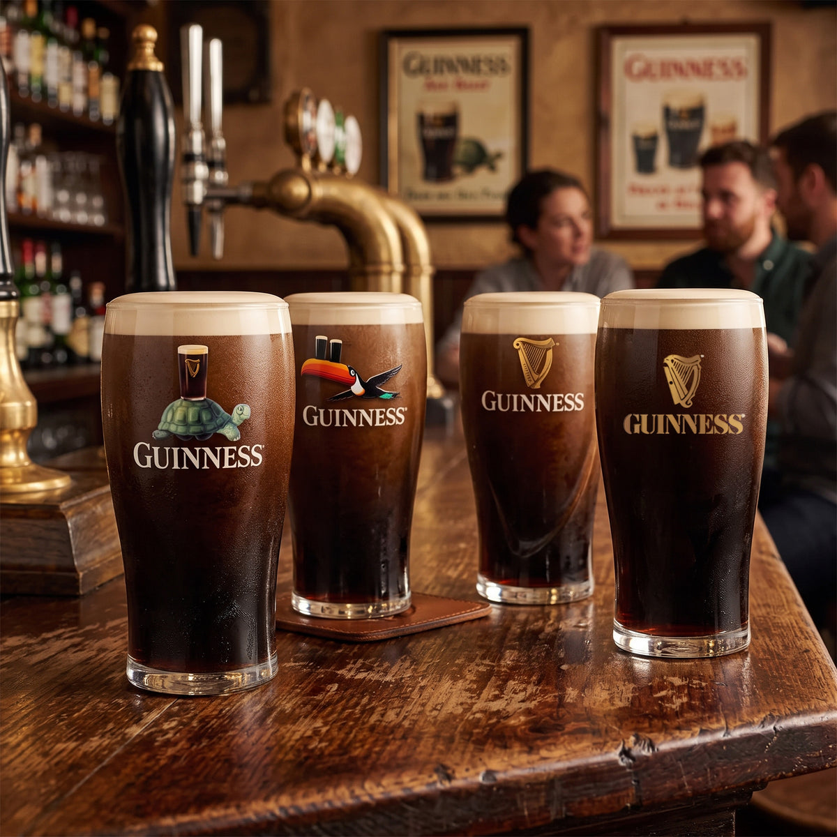 Four pints of Guinness stout served in the Guinness Collectors Edition Pint Glass Set from Guinness Webstore US rest on a wooden bar counter, while two men converse in the background and vintage Guinness posters adorn the walls—creating an inviting scene rich with Irish heritage.