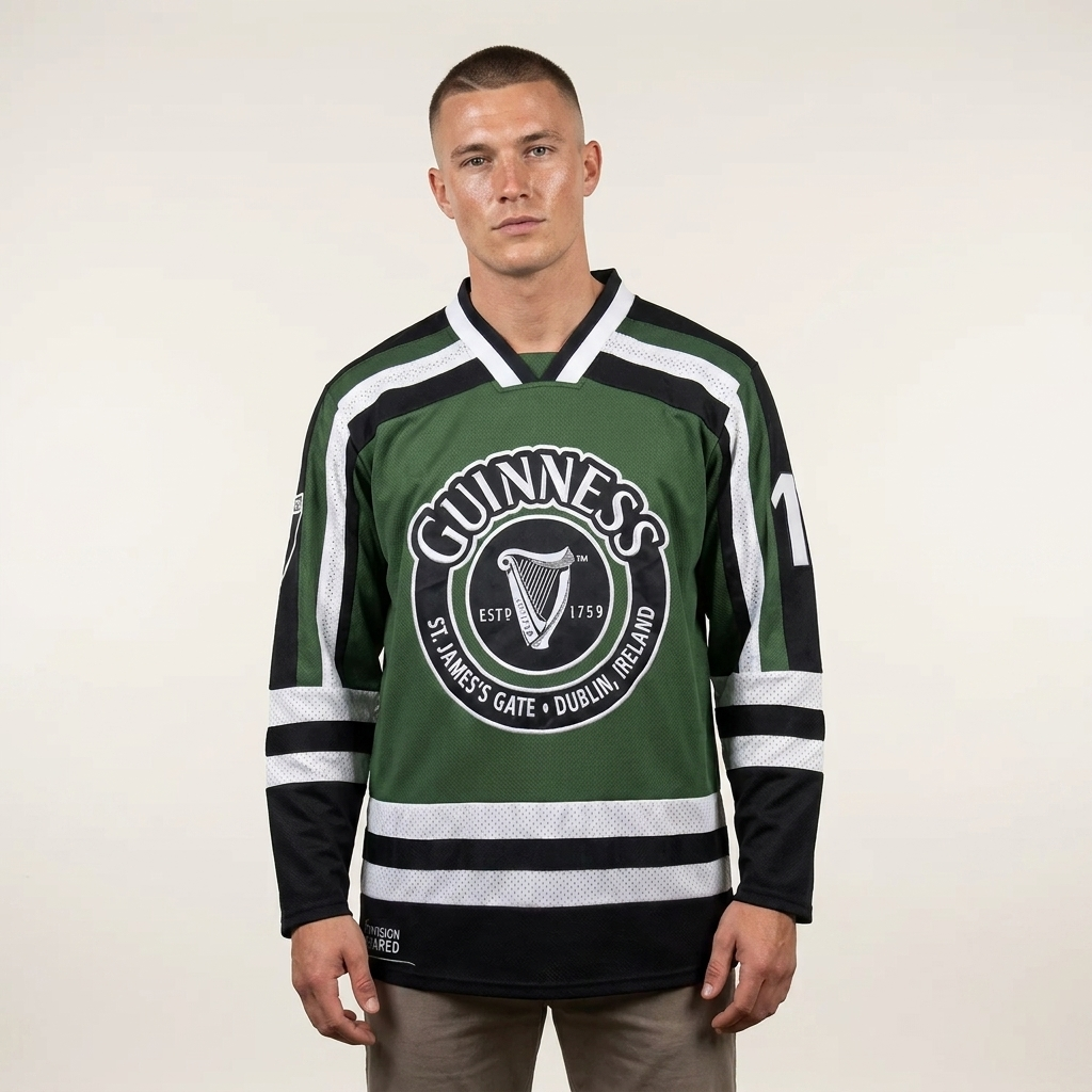 A person stands facing forward wearing the Guinness Green & White Hockey Jersey, featuring black and green colors with white stripes and Guinness logo text on the front, against a plain background.